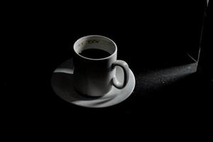 xícara de café em um fundo escuro foto