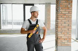 retrato do bonito masculino construtor dentro macacão e Difícil chapéu foto