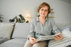 era e pessoas conceito - feliz Senior mulher lendo jornal às casa foto