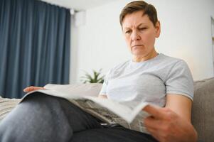 mulher lendo jornal às casa foto