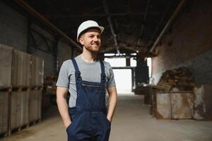 retrato do feliz masculino trabalhador dentro armazém em pé entre prateleiras. foto