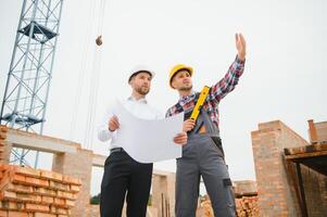 estrutural engenheiro e capataz trabalhador discutir, plano trabalhando para a ao ar livre construção construção local foto