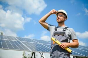 masculino trabalhador com solar baterias. homem dentro uma protetora capacete. instalando estar sozinho solar painel sistema foto