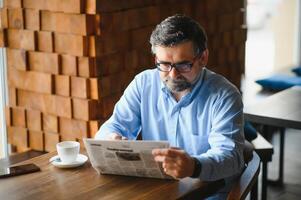 café pausa. homem bebendo café e lendo jornal dentro cafeteria Barra foto