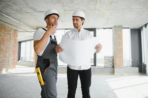 masculino arquiteto dando instruções para dele capataz às construção local. foto