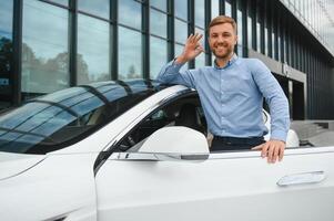 sempre disponível. bonito jovem homem de negocios perto dele carro ao ar livre foto