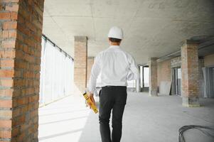 retrato do homem arquiteto às construção local. confiante construção Gerente vestindo capacete. bem sucedido maduro Civil engenheiro às construção local com cópia de espaço. foto