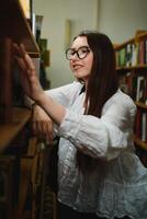 retrato de uma aluna estudando na biblioteca foto
