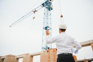 arquiteto às uma construção local com plantas foto