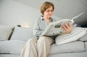 era e pessoas conceito - feliz Senior mulher lendo jornal às casa foto