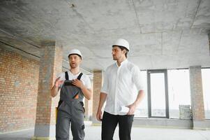 masculino arquiteto dando instruções para dele capataz às construção local. foto