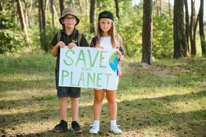 crianças estão segurando uma poster Salve  a planeta. terra dia. vamos Salve  a planeta a partir de poluição. foto