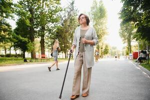 mulher com dela caminhando bastão dentro a parque. foto