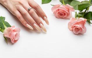 fêmea mãos em uma branco fundo com lindo pérola manicure foto