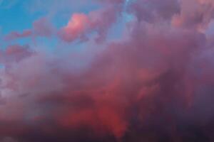 dramático céu com brilhante vermelho e Sombrio azul tormentoso nuvens. natureza fundo foto