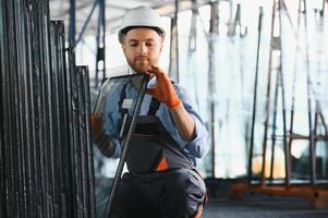 trabalhadores transferir a vidro. às a fábrica para a Produção do janelas e portas do alumínio e PVC foto