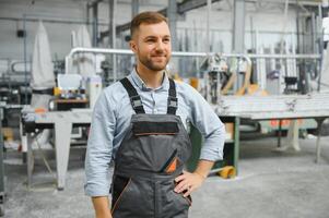 retrato do sorridente trabalhador em pé de industrial Produção máquina. foto