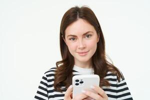 retrato do mulher verificação dela mensagens em Móvel telefone, olhando às Smartphone tela foto