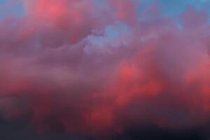 dramático céu com brilhante vermelho e Sombrio azul tormentoso nuvens. natureza fundo foto