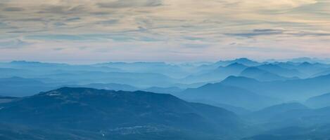 surpreendente zangão aéreo panorama às a italiano Alpes dentro inverno e outono. manhã panorama. outono nascer do sol às a Alpes com umidade e poluição dentro a ar. silhueta do a montanhas e colinas foto