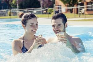 jovem amoroso casal relaxa e beber vinho foto