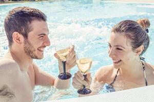 jovem amoroso casal relaxa e beber vinho foto