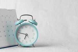 a alarme relógio e calendário posicionado em uma branco fundo simbolizar datas, tempo, planejamento, e compromissos. foto