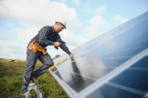 masculino trabalhador dentro uniforme ao ar livre com solar pilhas às ensolarado dia. foto