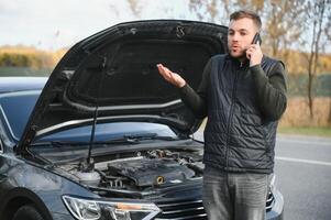 carro quebrou baixa em a estrada, uma homem chamadas a emergência serviço, uma rebocar caminhão. foto