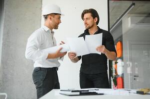 engenheiro ou arquiteto trabalho em equipe trabalhando em construção projeto com construção modelo e projeto dentro escritório. construção conceito. foto