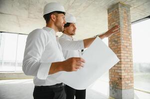 masculino arquiteto dando instruções para dele capataz às construção local. foto