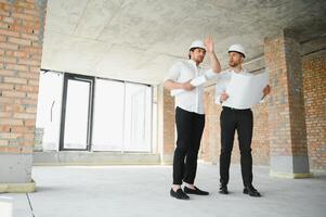 dois jovem homem arquiteto em uma construção construção local foto