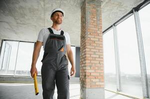 retrato do bonito masculino construtor dentro macacão e Difícil chapéu foto