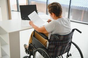 positivo idosos mulher dentro cadeira de rodas trabalhando em computador portátil, isto trabalhador autonomo, conectados foto