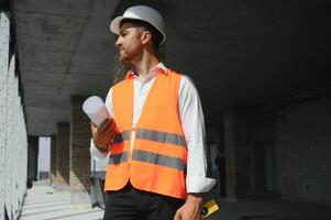 retrato do homem arquiteto às construção local. confiante construção Gerente vestindo capacete. bem sucedido maduro Civil engenheiro às construção local com cópia de espaço. foto