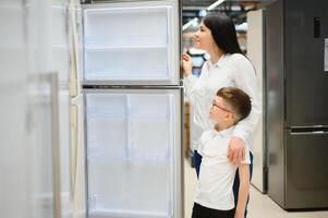 família usando doméstico geladeira dentro supermercado foto