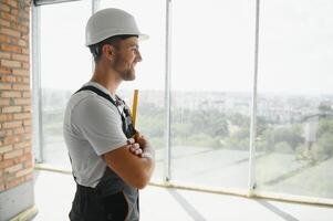 retrato do bonito masculino construtor dentro macacão e Difícil chapéu foto