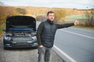 uma homem sentir estresse Porque dele carro é quebrado baixa foto