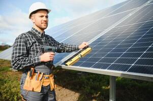 masculino trabalhador dentro uniforme ao ar livre com solar pilhas às ensolarado dia. foto