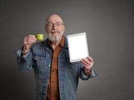 sorridente Senior homem com uma em branco digital tábua e uma copo do café, ensino e apresentação conceito foto