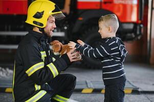 bombeiro segurando criança Garoto para Salve  ele dentro fogo e fumaça, bombeiros resgate a Rapazes a partir de fogo foto