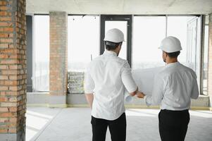 dois jovem homem arquiteto em uma construção construção local foto