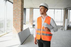 retrato do homem arquiteto às construção local. confiante construção Gerente vestindo capacete. bem sucedido maduro Civil engenheiro às construção local com cópia de espaço. foto