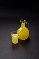 alcoólico beber amarelo limoncello dentro uma pequeno vidro foto