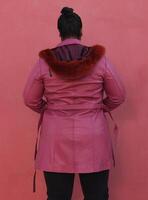 uma mulher dentro uma Rosa grandes casaco com pele e Preto calça foto