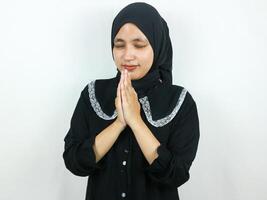 jovem muçulmano ásia mulher Rezar, fechamento olhos isolado em branco fundo foto