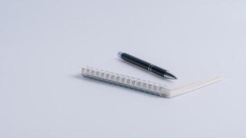 caderno e caneta fechar acima com uma borrado fundo dentro a primeiro plano em branco mesa fundo foto