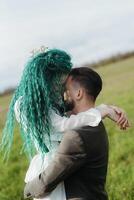 uma barbudo noivo e uma menina com verde cabelo dança e rodopio foto