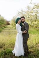 uma barbudo noivo e uma menina com verde cabelo estão caminhando foto