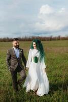 uma barbudo noivo e uma menina com verde cabelo dança e rodopio foto